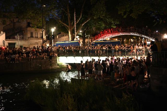 Partygoers bath in the Canal Saint-Martin during the annual street music festival 'Fete de la Musique' in Paris on June 21, 2026. (Photo by Arnaud FINISTRE / AFP)