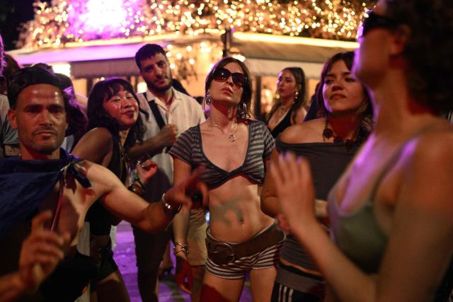 Partygoers dance at the Canal Saint-Martin during the annual street music festival 'Fete de la Musique' in Paris on June 21, 2026. (Photo by Arnaud FINISTRE / AFP)