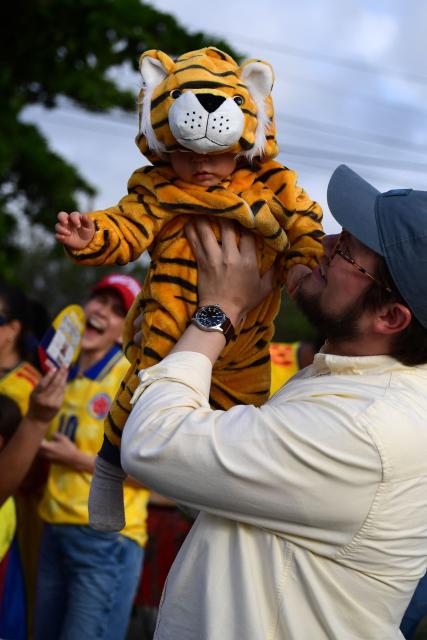 A supporters of Colombia's presidential candidate for the Defensores de la Patria movement, Abelardo de la Espriella, lifts a child wearing a tiger costume after the first results of the presidential election runoff at the Ventana al Mundo monument in Barranquilla, Colombia, on June 21, 2026. Colombians voted on June 21 in a polarized presidential runoff that could reshape the country's fragile peace process and relations with the United States, after the most violent election campaign in a decade. (Photo by Jaime SALDARRIAGA / AFP)