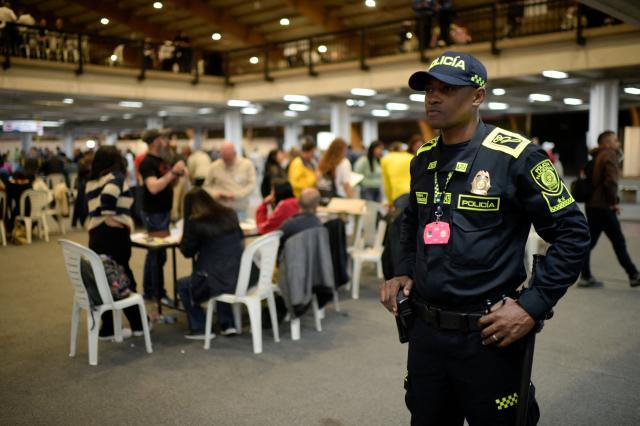 A police officer stands guard as electoral officials count votes at a polling station during the presidential election runoff in Bogota, Colombia, on June 21, 2026. Colombians voted on June 21 in a polarized presidential runoff that could reshape the country's fragile peace process and relations with the United States, after the most violent election campaign in a decade. (Photo by Sebastian BARROS / AFP)