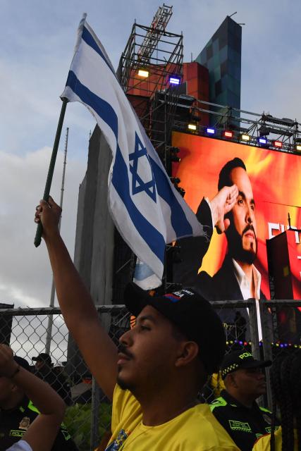 A supporter of Colombia's presidential candidate for the Defensores de la Patria movement Abelardo de la Espriella holds an Israeli flag as he celebrates the results of the presidential runoff election at the Ventana al Mundo monument in Barranquilla, Colombia, on June 21, 2026. A flamboyant US-backed lawyer who has never held public office narrowly won Colombia's presidential runoff on June 21, swinging the country hard to the right on a promise to wage war against drug-running guerrilla groups. With more than 99 percent of polling centers reporting, Abelardo de la Espriella had 49.67 percent of the vote, an unassailable lead over his rival, left-wing Senator Ivan Cepeda who trailed at 48.69 percent, according to official results. (Photo by Jaime SALDARRIAGA / AFP)