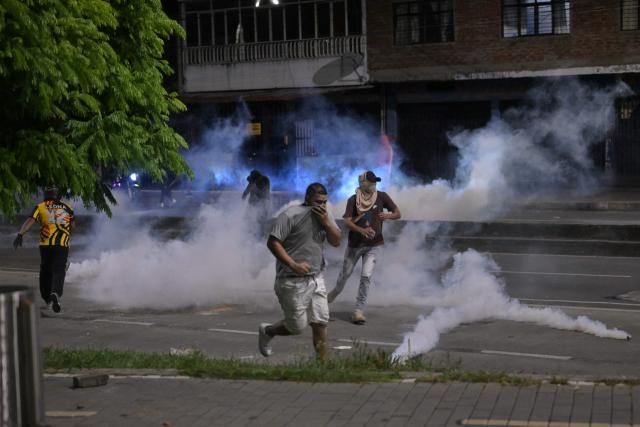 Supporters of Colombias presidential candidate Ivan Cepeda of the ruling Pacto Historico party run from tear gas as they protest the results of the presidential runoff election in Cali, Colombia, on June 21, 2026. A flamboyant US-backed lawyer who has never held public office narrowly won Colombia's presidential runoff Sunday, swinging the country hard to the right on a promise to wage war against drug-running guerrilla groups. With more than 99 percent of polling centers reporting, Abelardo de la Espriella had 49.67 percent of the vote, an unassailable lead over his rival, left-wing Senator Ivan Cepeda who trailed at 48.69 percent, according to official results. (Photo by JOAQUIN SARMIENTO / AFP)