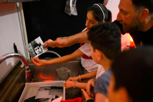 Children work in a darkroom during a workshop held as part of Fotohane Darkroom project in Mardin, southeastern Turkey, on June 14, 2026. In a dimly lit room illuminated by a pair of red lamps, eight-year-old Zeynep waits to see the photographs she has taken, now trapped as shadows and silhouettes on a roll of film. Originally from the southeastern province of Mardin, Zeynep is among eight children taking part in a two-month analog photography workshop for local and migrant youth near Turkey's borders with Iraq and Syria. The project, called Fotohane Darkroom, started in Mardin in 2024, by Kilic and Syrian photographer and educator Serbest Salih. In Turkish, Arabic, Kurdish and Persian, Fotohane means "house of photo", a name chosen by the children. (Photo by Yasin AKGUL / AFP)