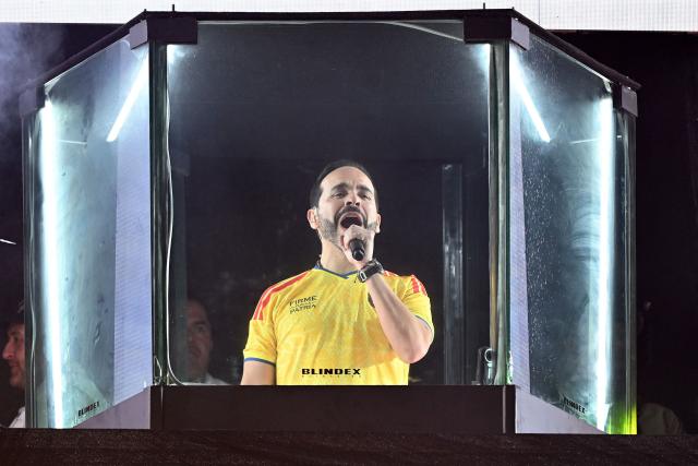 Colombia's presidential candidate for the Defensores de la Patria movement, Abelardo de la Espriella, speaks to supporters from behind bullet-proof glass following the preliminary results of the presidential runoff election at the Ventana al Mundo monument in Barranquilla, Colombia, on June 21, 2026. A flamboyant US-backed lawyer who has never held public office narrowly won Colombia's presidential runoff on June 21, swinging the country hard to the right on a promise to wage war against drug-running guerrilla groups. With just a handful of polling centers left to report, Abelardo de la Espriella had 49.65 percent of the vote -- an unassailable lead over left-wing Senator Ivan Cepeda who trailed on 48.70 percent. (Photo by Juan BARRETO / AFP)