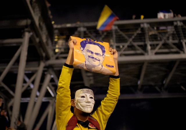 A supporter of Colombia's presidential candidate Ivan Cepeda of the ruling Pacto Historico party wears a Guy Fawkes mask following results of the presidential runoff election in Bogota on June 21, 2026. A flamboyant US-backed lawyer who has never held public office narrowly won Colombia's presidential runoff on June 21, swinging the country hard to the right on a promise to wage war against drug-running guerrilla groups. With more than 99 percent of polling centers reporting, Abelardo de la Espriella had 49.67 percent of the vote, an unassailable lead over his rival, left-wing Senator Ivan Cepeda who trailed at 48.69 percent, according to official results. (Photo by Sebastian BARROS / AFP)