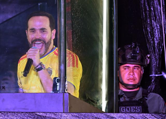 Colombia's presidential candidate for the Defensores de la Patria movement, Abelardo de la Espriella, speaks to supporters from behind bullet-proof glass following the preliminary results of the presidential runoff election at the Ventana al Mundo monument in Barranquilla, Colombia, on June 21, 2026. A flamboyant US-backed lawyer who has never held public office narrowly won Colombia's presidential runoff on June 21, swinging the country hard to the right on a promise to wage war against drug-running guerrilla groups. With just a handful of polling centers left to report, Abelardo de la Espriella had 49.65 percent of the vote -- an unassailable lead over left-wing Senator Ivan Cepeda who trailed on 48.70 percent. (Photo by Juan BARRETO / AFP)