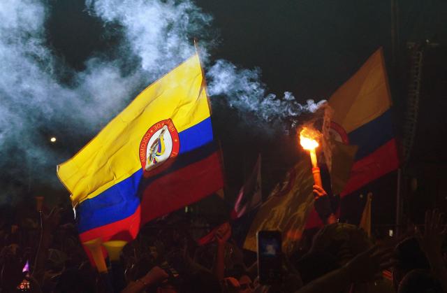 Supporters of Colombia's presidential candidate for the Defensores de la Patria movement, Abelardo de la Espriella, light flares following the preliminary results of the presidential runoff election at the Ventana al Mundo monument in Barranquilla, Colombia, on June 21, 2026. A flamboyant US-backed lawyer who has never held public office narrowly won Colombia's presidential runoff on June 21, swinging the country hard to the right on a promise to wage war against drug-running guerrilla groups. With just a handful of polling centers left to report, Abelardo de la Espriella had 49.65 percent of the vote -- an unassailable lead over left-wing Senator Ivan Cepeda who trailed on 48.70 percent. (Photo by Vanexa Romero / AFP)