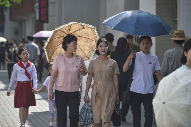 People walk along a street near the railway station in Pyongyang on June 22, 2026. (Photo by KIM Won Jin / AFP)