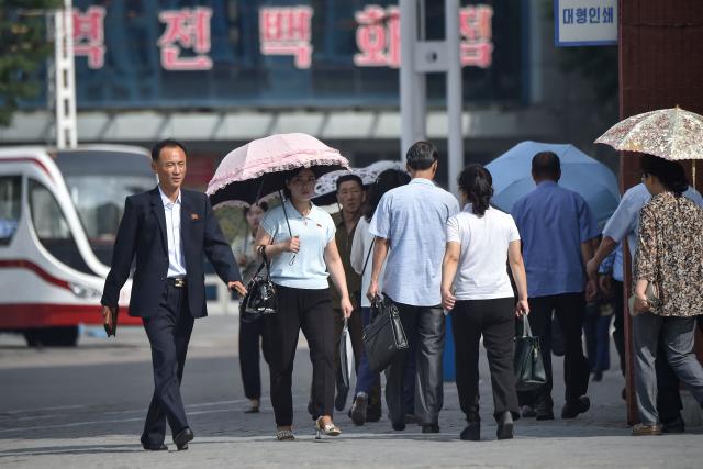People walk along a street near the railway station in Pyongyang on June 22, 2026. (Photo by KIM Won Jin / AFP)