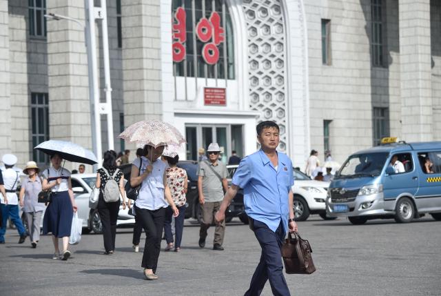 People walk along a street near the railway station in Pyongyang on June 22, 2026. (Photo by KIM Won Jin / AFP)