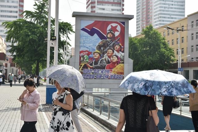 People walk along a street near the railway station in Pyongyang on June 22, 2026. (Photo by KIM Won Jin / AFP)