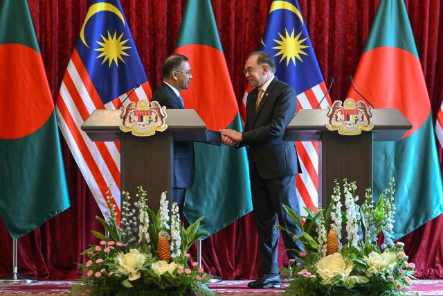 Bangladesh's Prime Minister Tarique Rahman (L) and Malaysia's Prime Minister Anwar Ibrahim shake hands during a press conference at the Federal Government office "Putra Perdana" in Putrajaya on June 22, 2026. (Photo by MOHD RASFAN / POOL / AFP)
