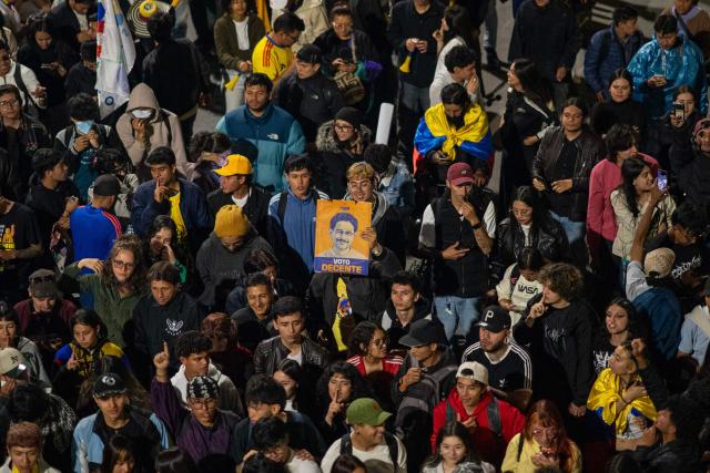 Demonstrators hold a poster of left wing candidate Ivan Cepeda as they gather in protest over the preliminary results of the presidential runoff election in Bogota, Colombia, on June 21, 2026. A flamboyant US-backed lawyer who has never held public office narrowly won Colombia's presidential runoff Sunday, swinging the country hard to the right on a promise to wage war against drug-running guerrilla groups. With more than 99 percent of polling centers reporting, Abelardo de la Espriella had 49.67 percent of the vote, an unassailable lead over his rival, left-wing Senator Ivan Cepeda who trailed at 48.69 percent, according to official results. (Photo by Diego Cuevas / AFP)