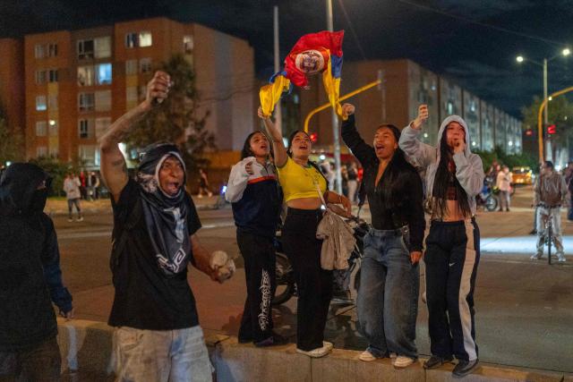 Protesters wave flags and hold rocks during clashes over the preliminary results of the presidential runoff election in Bogota, Colombia, on June 21, 2026. A flamboyant US-backed lawyer who has never held public office narrowly won Colombia's presidential runoff Sunday, swinging the country hard to the right on a promise to wage war against drug-running guerrilla groups. With more than 99 percent of polling centers reporting, Abelardo de la Espriella had 49.67 percent of the vote, an unassailable lead over his rival, left-wing Senator Ivan Cepeda who trailed at 48.69 percent, according to official results. (Photo by Diego Cuevas / AFP)