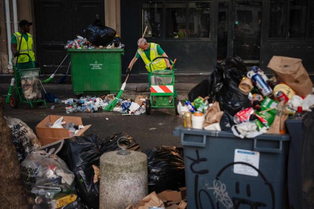 Municipal workers clean up food and drink waste on a street around the Canal Saint-Martin after the national annual street music festival 'Fete de la Musique' in Paris on June 22, 2026. (Photo by DIMITAR DILKOFF / AFP)