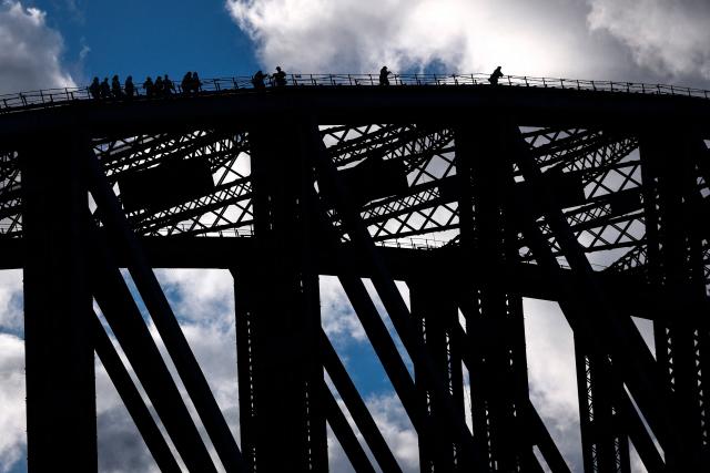 Tourists climb the arch of the Sydney Harbour Bridge on a cold winter's day in Sydney on June 22, 2026. (Photo by DAVID GRAY / AFP)