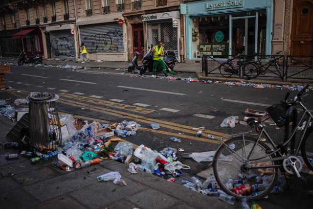 Municipal workers clean up food and drink waste on the morning following the national annual street music festival 'Fete de la Musique' in Paris on June 22, 2026. (Photo by DIMITAR DILKOFF / AFP)