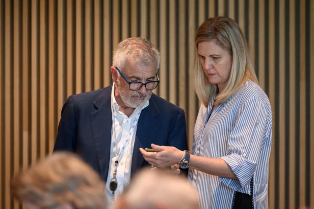 International Olympic Committee president (IOC) Kirsty Coventry (R) reacts as she looks at a smartphone next to IOC vice-president Juan Antonio Samaranch prior to an IOC executive commission meeting ahead of IOC session, at the Olympic House in Lausanne, on June 22, 2026. (Photo by Fabrice COFFRINI / AFP)