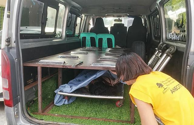 EDITORS NOTE: Graphic content / Jennelyn Badoria, mother of one of the slain students, looks at the dead body of her daughter inside an ambulance after a shooting incident at a high school compound in Tacloban City, Leyte province on June 22, 2026. At least three teenaged students were killed and five others wounded on June 22, in a rare school shooting in the central Philippines, police said. (Photo by Noel  Sianosa / AFP)