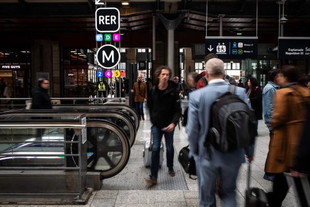 (FILES) Commuters walk at the Gare du Nord, Europe's busiest train station and the third in the world, on April 3, 2024 in Paris. One in ten trains is being cancelled on June 22, 2026, in the Ile-de-France region as a preventive measure, in order to protect the railway network infrastructure, which will be under heavy strain from the heatwave in the coming days, said Valerie Pécresse, president of Ile-de-France Mobilites (IDFM), and SNCF Reseau. (Photo by Guillaume BAPTISTE / AFP)