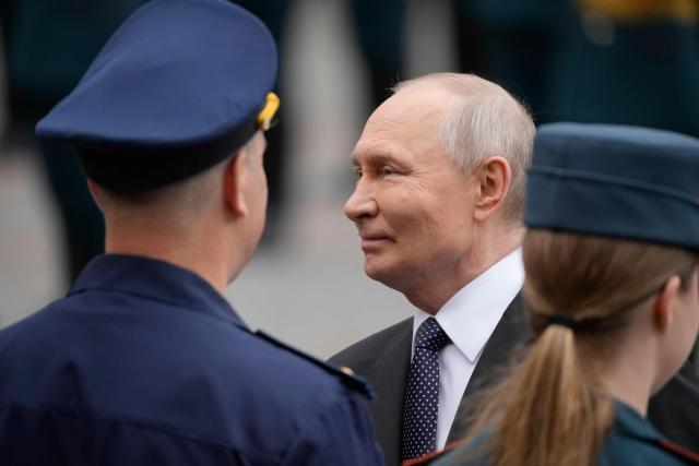 Russian President Vladimir Putin speaks with officers during a wreath-laying ceremony marking the 85th anniversary of the Nazi Germany invasion into the Soviet Union in World War II on the Remembrance and Sorrow Day at the Tomb of the Unknown Soldier by the Kremlin wall in Moscow on June 22, 2026. (Photo by Pavel Bednyakov / POOL / AFP)