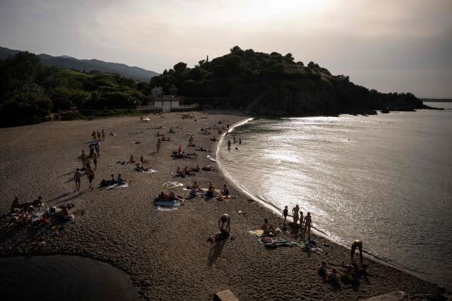 Beachgoers enjoy the sun on the beach of l'Ouille on the coast of the Mediterranean Sea, in Argeles-sur-Mer in the Pyrenees-Orientales department, southwestern France on June 20, 2026. (Photo by Lionel BONAVENTURE / AFP)
