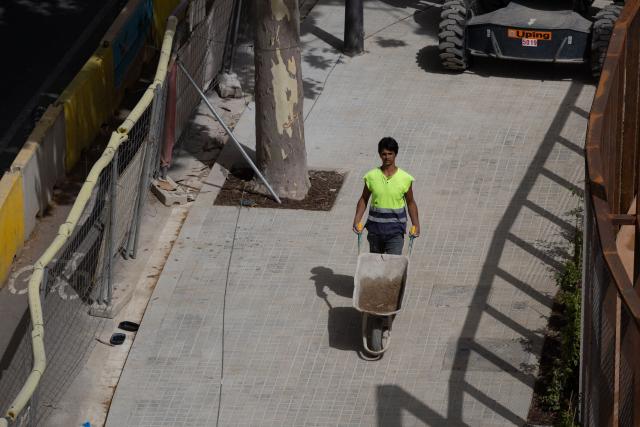 A worker is pictured in a street in Barcelona on June 22, 2026, during the heat wave that is affecting the Iberian Peninsula. Large parts of Spain experience unusually high temperatures for June as a mass of hot air from North Africa moves across the Iberian Peninsula. (Photo by Josep LAGO / AFP)