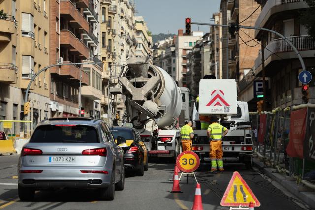 Workers are pictured a street in Barcelona on June 22, 2026, during the heat wave that is affecting the Iberian Peninsula. Large parts of Spain experience unusually high temperatures for June as a mass of hot air from North Africa moves across the Iberian Peninsula. (Photo by Josep LAGO / AFP)