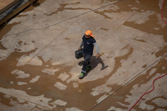 A worker is pictured in a street in Barcelona on June 22, 2026, during the heat wave that is affecting the Iberian Peninsula. Large parts of Spain experience unusually high temperatures for June as a mass of hot air from North Africa moves across the Iberian Peninsula. (Photo by Josep LAGO / AFP)