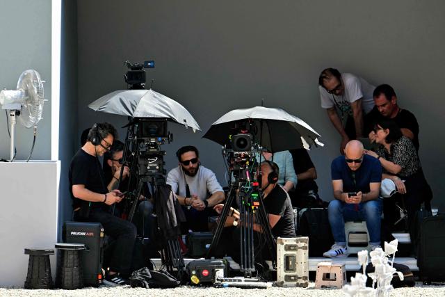 Photographers and cameramen wait in the shade before the Thom Browne collection show at Milan's Fashion Week Menswear Spring/Summer 2027, in Milan on June 22, 2026. (Photo by Stefano RELLANDINI / AFP)