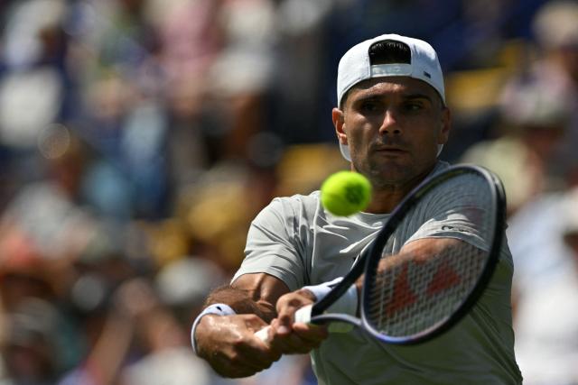 US player Marcos Giron returns to Britain's Jack Draper during their men's singles round of 32 tennis match on day one of the Lexus Eastbourne Open at Devonshire Park, Eastbourne, on the south coast of England on June 22, 2026. (Photo by Glyn KIRK / AFP)