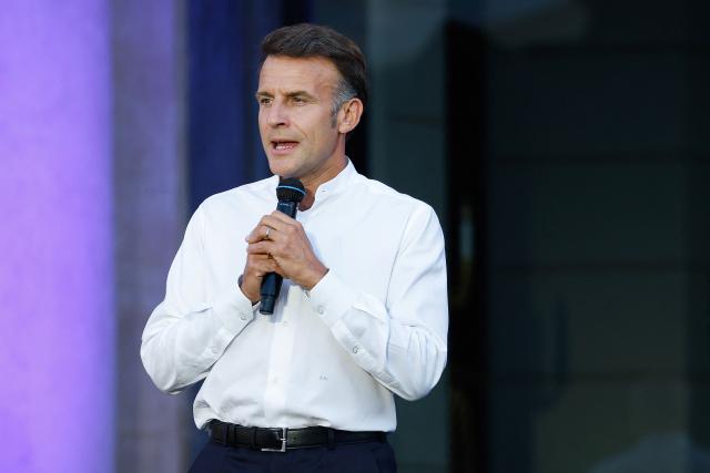 France's President Emmanuel Macron addresses attendees during the annual street music festival 'Fete de la Musique' and amid a heat wave at the Presidential Elysee Palace in Paris on June 21, 2026. (Photo by Yoan VALAT / POOL / AFP)