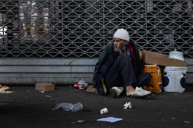 A homelesss person sits on the pavement with the heatwave set to intensify across much of Europe, forcing warnings and special measures, in Paris on June 20, 2026. (Photo by Joel Saget / AFP)