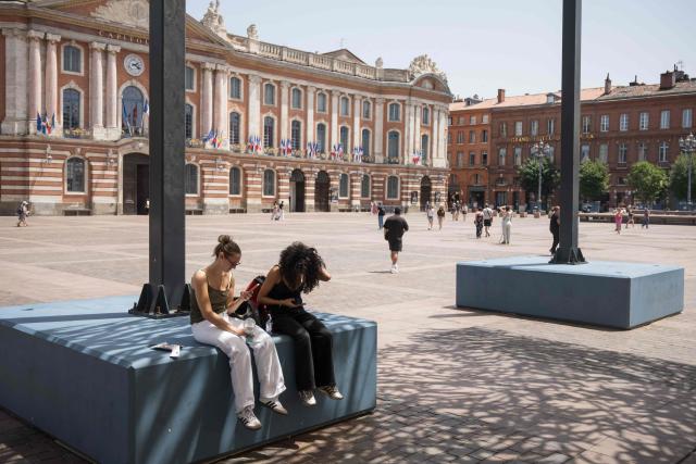 People sit in the shade in Toulouse during a heatwave on June 22, 2026. (Photo by Ed JONES / AFP)