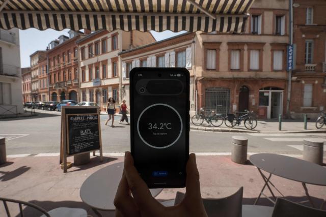 A thermometer-enabled phone shows the temperature of the glass of a cafe window on a street in Toulouse during a heatwave on June 22, 2026. (Photo by Ed JONES / AFP)