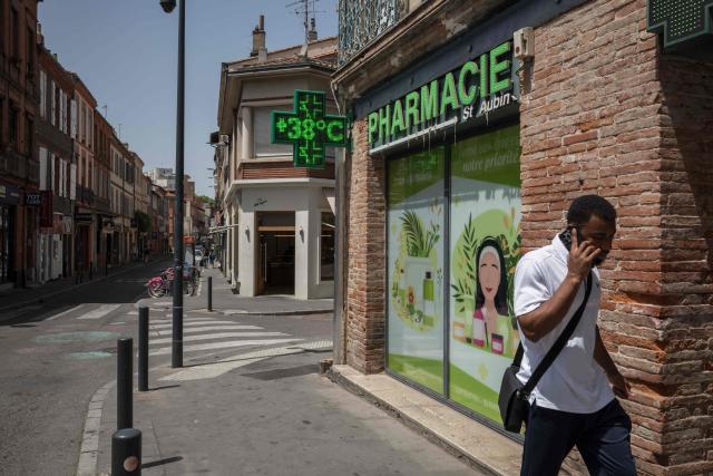 A man walks past a pharmacy showing the temperature on a display in Toulouse during a heatwave on June 22, 2026. (Photo by Ed JONES / AFP)