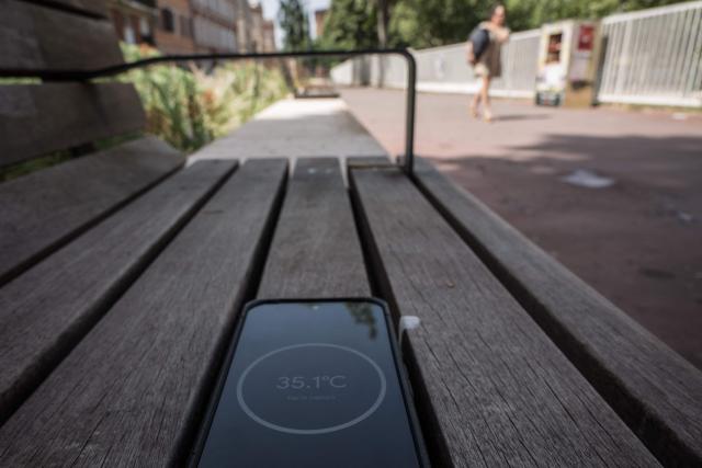 A thermometer-enabled telephone shows the temperature of a shaded bench on a street in Toulouse during a heatwave on June 22, 2026. (Photo by Ed JONES / AFP)