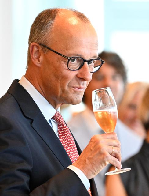 Germany's Chancellor Friedrich Merz raises his glass during a reception of medal winners from the 2026 Olympic and Paralympic Winter Games in Berlin, on June 22, 2026. (Photo by Tobias SCHWARZ / AFP)