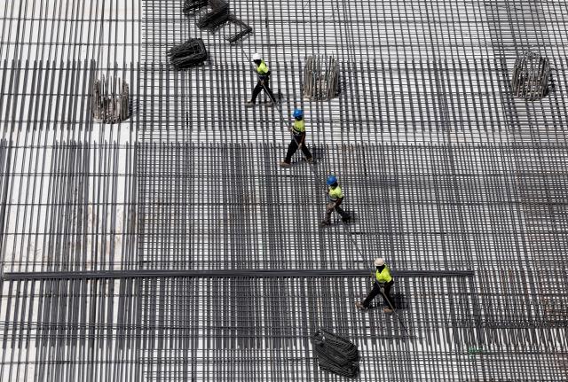 Workers install metallic structure at a construction site for a bus terminal in Madrid on June 22, 2026, during the heat wave affecting the Iberian Peninsula. National weather agency AEMET issued an orange heat warning – the second-highest level - for the Madrid region, with temperatures forecast to reach 40C. Large parts of Spain experience unusually high temperatures for June as a mass of hot air from North Africa moves across the Iberian Peninsula. (Photo by OSCAR DEL POZO / AFP)