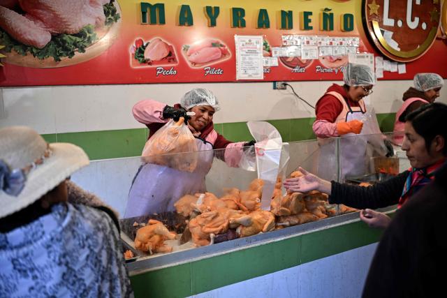 People buy chicken at a commercial establishment in downtown La Paz, Bolivia, on June 22, 2026. Bolivian police driving bulldozers cleared highways on June 21, 2026 and fuel trucks rolled into La Paz after the president declared a state of emergency to remove anti-government roadblocks that had paralyzed the Andean nation. (Photo by MARTIN BERNETTI / AFP)