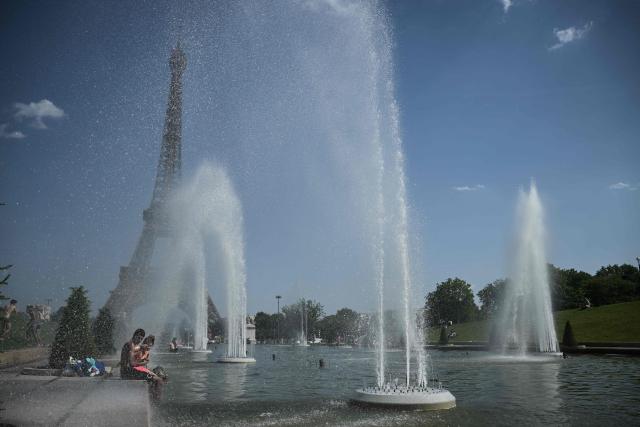People jump in the Trocadero Fountain near the Eiffel Tower during a heatwave in Paris on June 22, 2026. The latest bout of exceptionally high temperatures to hit Europe has seen outdoor events cancelled, transport disrupted, schools shut and office workers told to work from home, as the authorities issued health alerts to protect the elderly and vulnerable. In France, the epicentre of the weather anomaly, 54 of the country's 96 mainland departments were on the highest heat alert, with temperatures forecast to climb up to 43C in the southwestern city of Bordeaux and 39C in the capital Paris, said national weather service Meteo-France. (Photo by JULIEN DE ROSA / AFP)