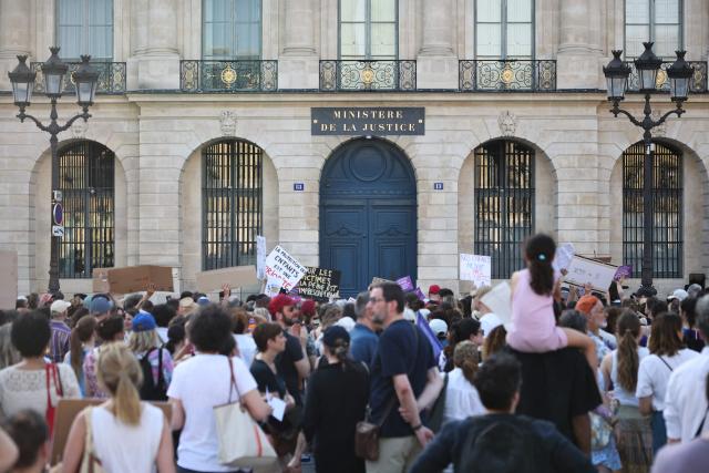 Protesters gather and hold placards during a demonstration at Place Vendome outside the French Justice Ministry in Paris on June 22, 2026 to demand a law against violence on minors, following the death of Lyhanna, an 11-year-old girl found dead on June 4 after being reported missing on May 29. (Photo by SIMON WOHLFAHRT / AFP)