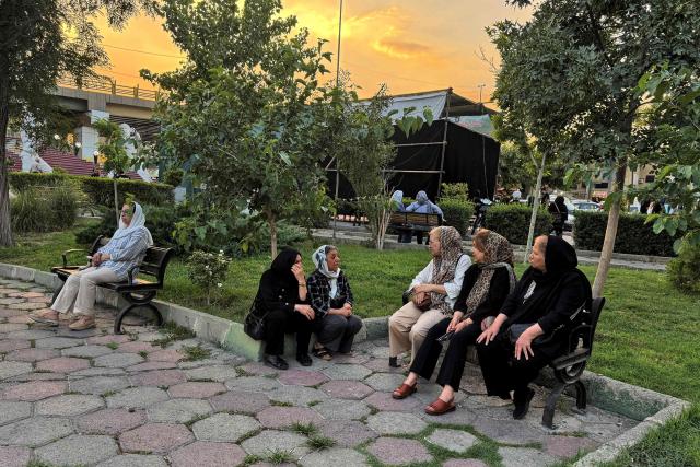 Iranians chat in a park in Tehran on June 22, 2026. The United States temporarily suspended sanctions on Iranian oil on June 22 after Vice President JD Vance said Iran would allow UN nuclear inspectors to return to the country, following talks in Switzerland. (Photo by ATTA KENARE / AFP) / 