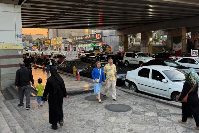 People and traffic move in the Iranian capital Tehran on June 22, 2026. The United States temporarily suspended sanctions on Iranian oil on June 22 after Vice President JD Vance said Iran would allow UN nuclear inspectors to return to the country, following talks in Switzerland. (Photo by ATTA KENARE / AFP) / 