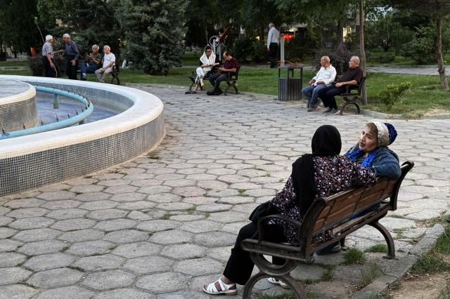 Iranians chat in a park in Tehran on June 22, 2026. The United States temporarily suspended sanctions on Iranian oil on June 22 after Vice President JD Vance said Iran would allow UN nuclear inspectors to return to the country, following talks in Switzerland. (Photo by ATTA KENARE / AFP) / 