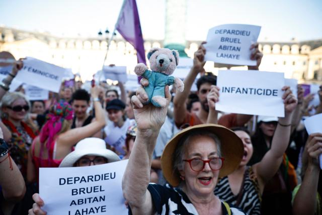 A protester holds a soft toy as a symbol of childhood during a demonstration at Place Vendome outside the French Justice Ministry in Paris on June 22, 2026 to demand a law against violence on minors, following the death of Lyhanna, an 11-year-old girl found dead on June 4 after being reported missing on May 29. (Photo by SIMON WOHLFAHRT / AFP)