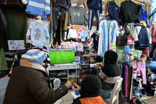 Argentina fans watch the 2026 FIFA World Cup football match between Argentina and Austria on a TV at a store in Buenos Aires on June 22, 2026. (Photo by Luis ROBAYO / AFP)