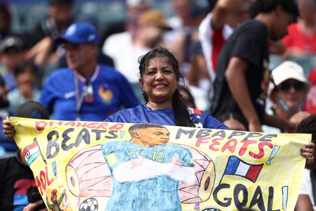 A French fan shows a sign depcting France's forward #10 Kylian Mbappe ahead of the 2026 World Cup Group I football match between France and Iraq at the Philadelphia Stadium in Philadelphia on June 22, 2026.  (Photo by FRANCK FIFE / AFP)
