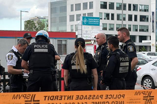 Damaged windows can be seen in the distance (top R) as police gather near the scene of a shooting in Montreal on June 22, 2026, which left three people dead. A midday shooting in Montreal killed three people on Monday, including a police officer, a civilian, and the alleged gunman, triggering rare alarm in the Canadian city. The bloodshed occurred in a partly Jewish neighborhood that includes kosher markets and restaurants, but police declined to comment on what the motive might have been and whether the incident amounted to a hate crime or act of terror. (Photo by Daphné LEMELIN / AFP)