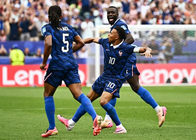 France's forward #10 Kylian Mbappe (C) celebrates scoring his team's first goal with defender #05 Jules Kounde (L) and defender #04 Dayot Upamecano during the 2026 World Cup Group I football match between France and Iraq at the Philadelphia Stadium in Philadelphia on June 22, 2026.  (Photo by Jewel SAMAD / AFP)